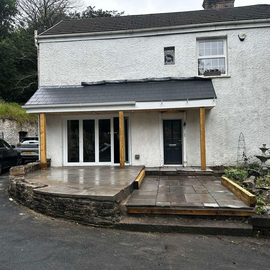 Slate-roofed canopy on timber posts over a new stone patio