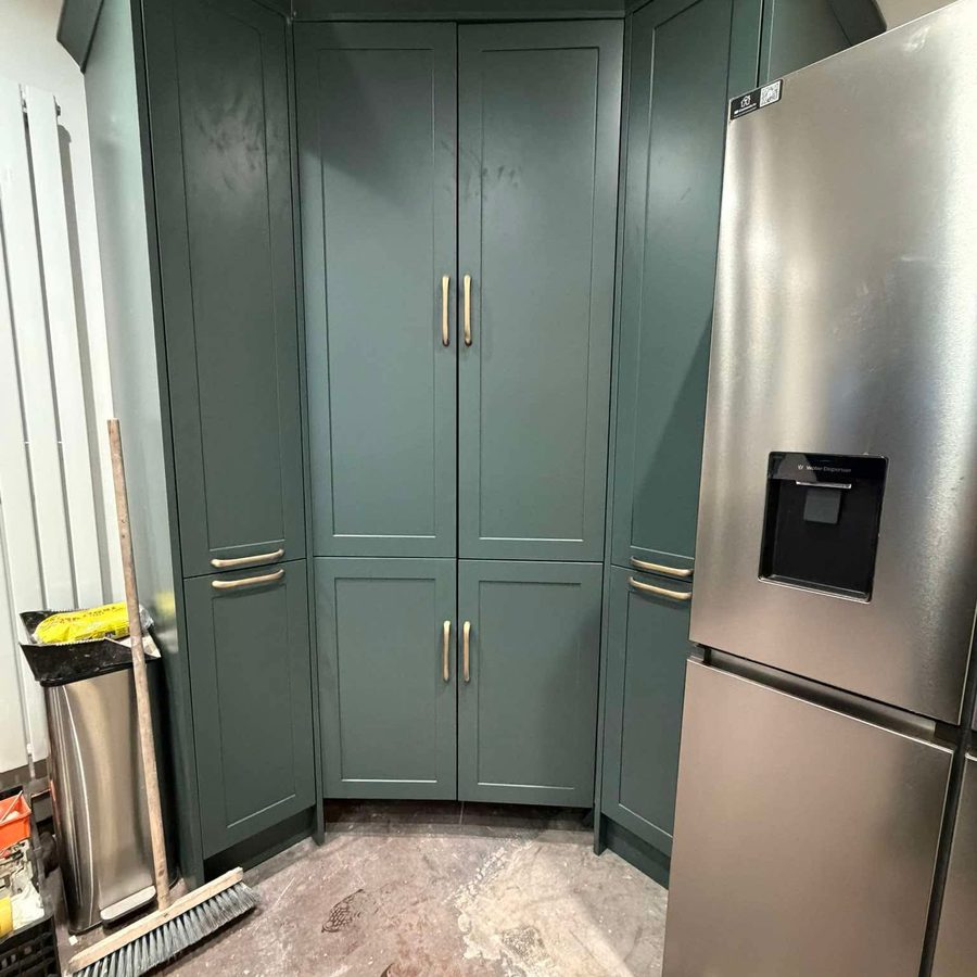 Tall green larder units with brass handles