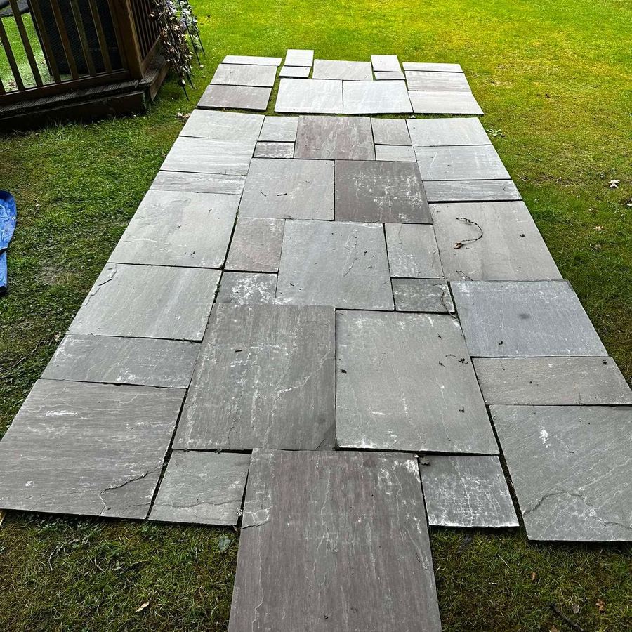 Natural stone path being laid across a lawn